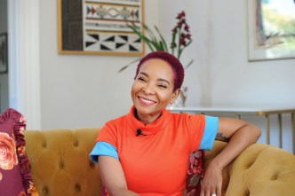 Mamokgethi Phakeng smiling at the camera, sitting on a yellow sofa